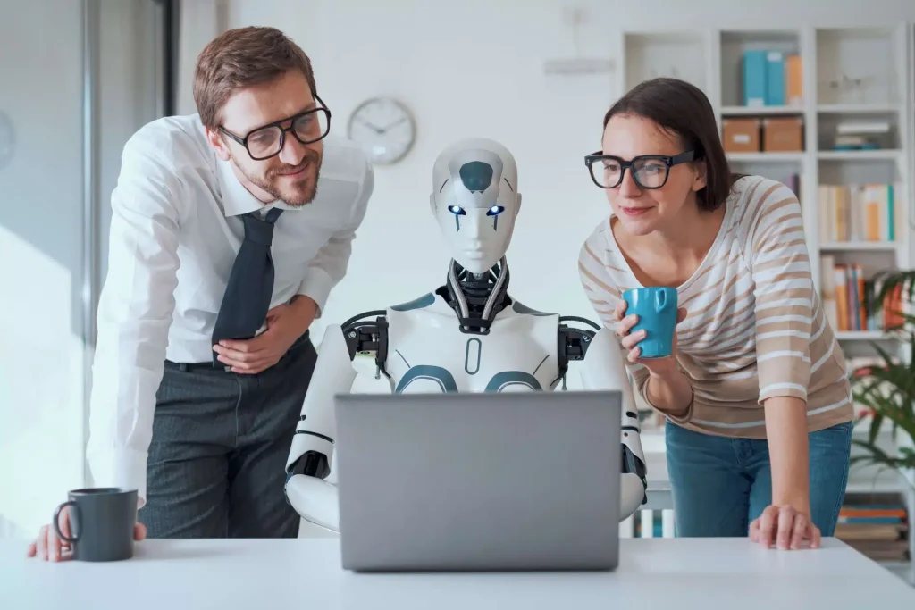A man and woman gaze at a laptop screen featuring a robot, reflecting their fascination with advancements in robotics.